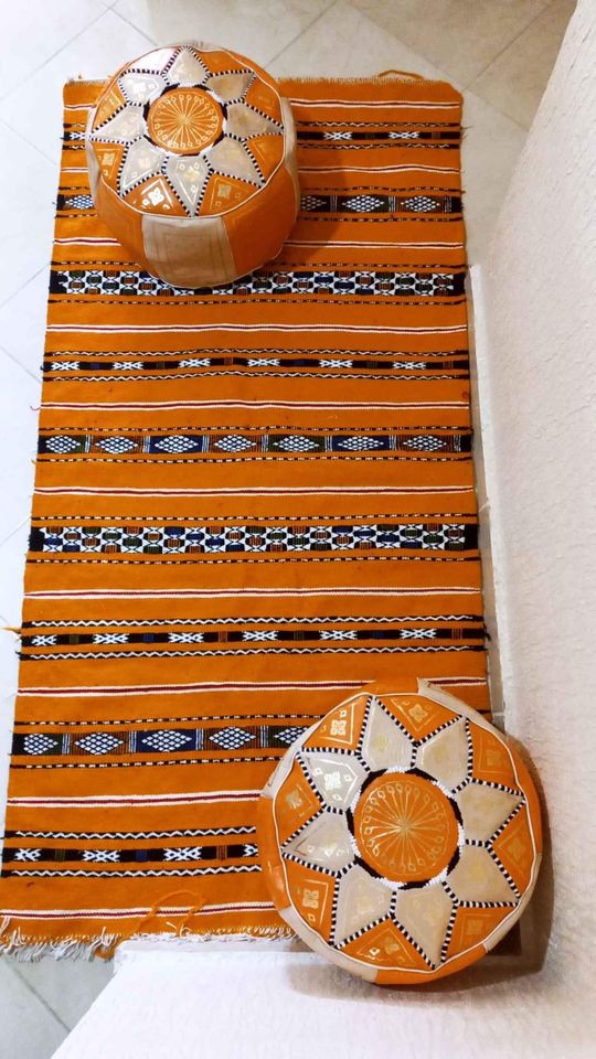 Tapis artisanal marocain : Ce tapis, issu de la tradition berbère, est une pièce unique. Les couleurs vives et les motifs géométriques créent un contraste saisissant et apporteront une touche d'originalité à votre décoration